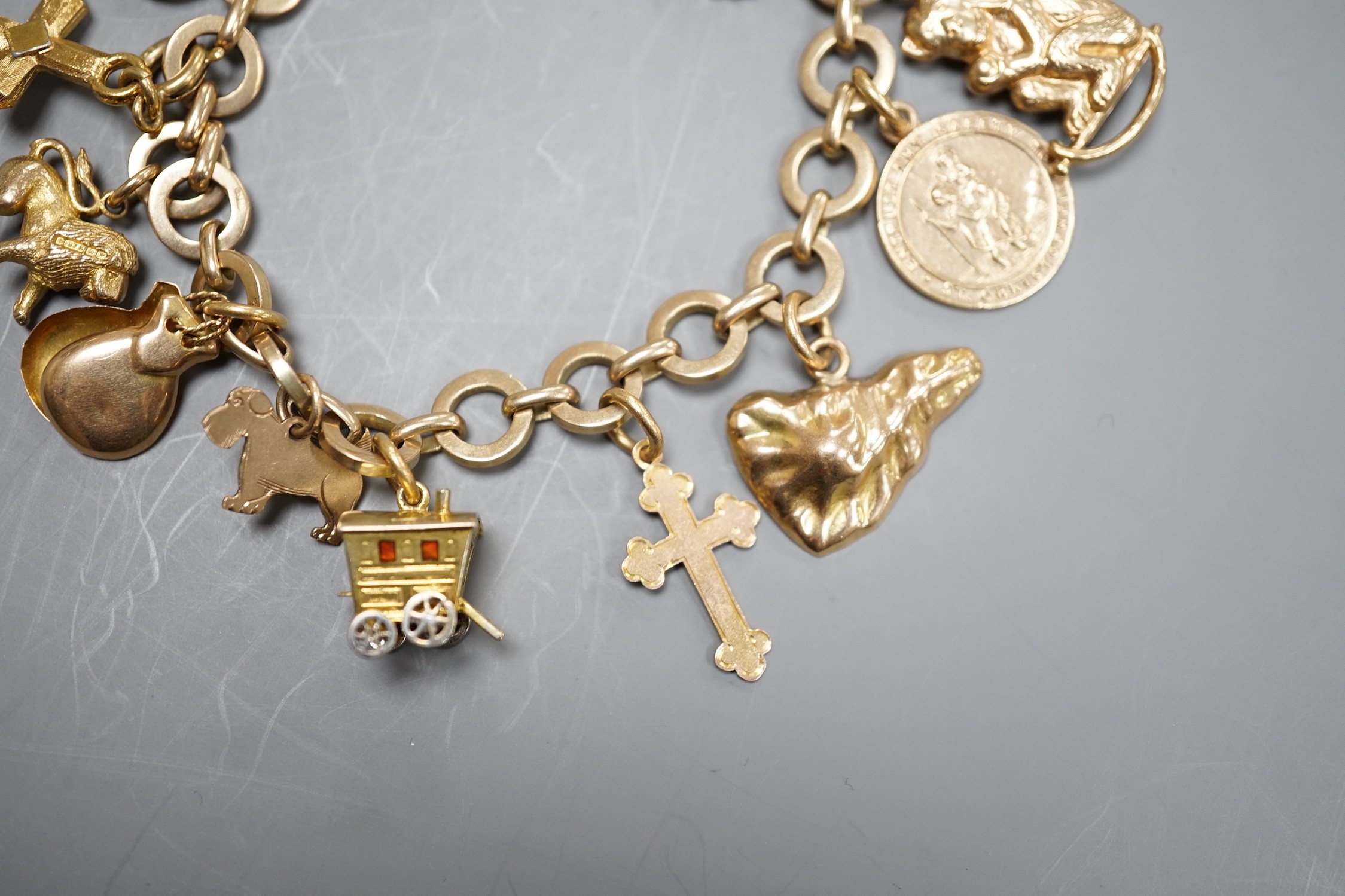 A 9ct gold charm bracelet, hung with assorted charm, including wagon, key, monkey etc. including six 9ct and one 18ct gold, gross weight 33.6 grams.